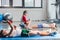 Little boys lying on yoga mat and using smartphone while friends exercising in gym