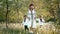 Little boys with mother walking in dandelions between apple trees. Ukrainian family in vyshyvanka, brothers and mom