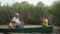 little boys with older parent while fishing, grandfather with glasses give grandson fishing rod while sitting on a boat