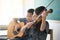 Little boys play and practice violin in music class room