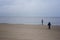 Little boys stands on beach the sea on cold windy day