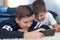 Little boys using smartphone on carpet and smile