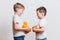 Little boys in white t-shirts with fruit in hand