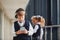 Little boywith phone and headphones standing if front of school kids in uniform that together in corridor. Conception of education