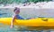 Little brave cute girl kayaking in the clear blue