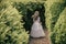 Little bridesmaid standing in a green garden