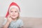 Little bright girl with a beautiful smile in a santaclaus cap