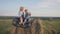 Little brother and older sister sitting on a haystack in a field at sunset and drink milk.