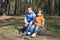 Little brother and sister sitting on a stump.