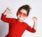 Little brunet boy in sunglasses, red jumper. He smiling, raised his hands up, posing isolated on white studio background