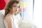 Little brunette girl sit on sofa window light