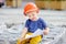 Little builder in hardhats reading construction drawing