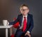Little businessman in the office. Child in suit, red necktie and glasses. Fashion kid in elegant suit studying in