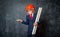 Little businessman in suit wearing safety red hard hat. time for check. Portrait of child makes hands gesture and