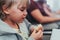 little candid kid boy five years old eats burger or sandwich food sitting in airplane seat