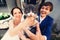 Little cat looks surprised being held by newlyweds