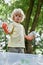 Little caucasian boy holding plastic waste while cleaning and collecting garbage in the forest or park