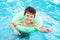 Little caucasian boy learning swim with saver