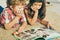 Little Caucasian boy and Spanish girl lying on the floor and reading an illustrated book.