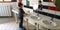 Little caucasian boy washes his hands himself in children`s toilet in kindergarten,standing with his back to the camera