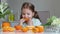 Little caucasian child eating sour fruit, oranges. Vitamin nutrition.