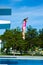 Little caucasian female 8 years old girl jumping from a diving platform