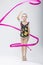 Little Caucasian Female Rhythmic Gymnast In Professional Competitive Suit Doing Artistic Ribbon Spirals