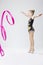 Little Caucasian Female Rhythmic Gymnast In Professional Competitive Suit Doing Artistic Ribbon Spirals Exercises