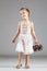 Little caucasian girl holding tiny shopping cart with pinecones