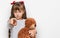 Little caucasian girl kid hugging teddy bear stuffed animal pointing with finger to the camera and to you, confident gesture