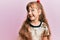 Little caucasian girl kid wearing festive sequins dress looking away to side with smile on face, natural expression
