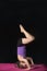 Little caucasian girl practing headstand pose