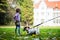 Little caucasian kids running around the autumn park with the dogs.