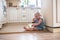 Little Caucasian Toddler funny girl with pigtails eating ice cream from a jar sitting on floor