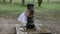 Little charming baby girl in a dress drinking water from a Roman fountain on a hot summer day