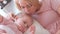 Little charming blond girl plays with baloon with her mom in pink dress laying on bed.