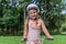 Little charming girl in a bicycle helmet rides a bicycle in the park