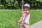 Little charming girl in a bicycle helmet rides a bicycle in the park