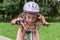 Little charming girl in a bicycle helmet rides a bicycle in the park