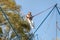 Little charming girl child on elastic ropes jumps on a trampoline in an amusement park