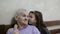 Little charming girl child granddaughter hugs with an elderly grandmother