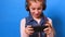 Little charming girl in headphones playing the video game on her smartphone and smiling