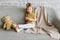 Little charming girl sits on a gray sofa.