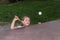 Little charming happy girl child plays ping pong on the street