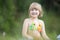 A little cheerful girl in a bright bathing suit on a green lawn on a warm summer day. Beautiful portrait of a charming girl