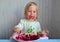 Little cheerful girl eats beets