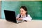 Little cheerful girl in glasses with a computer laptop. Science, school, entertainment