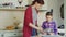 Little cheerful girl helping her mom in the kitchen cropping egg into bowl and mixing dough for cookies. Family, food