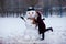 A little cheerful girl kiss funny snowman face