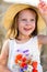 Little cheerful girl in a straw hat with wild flowers red poppy bouquet